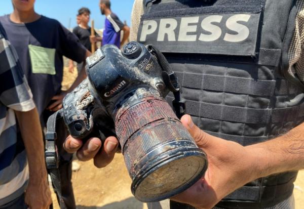 Un journaliste dans la bande de Gaza tient le 25 août 2025 l'appareil appartenant à la photojournaliste palestinienne Mariam Dagga, tuée dans une frappe israélienne 
