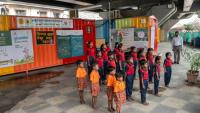 Des élèves chantent l'hymne national indien à "l'école du feu rouge" qui accueille des enfants défavorisés dans des conteneurs aménagés en salles de cours sous un pont autoroutier, le 18 mai 2026 à Bombay