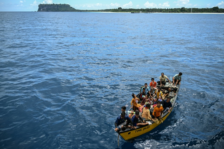 Des passagers sur un canot s'apprêtent à monter à bord  du ferry Kalighat, l'unique lien entre Chowra et Car Nicobar, deux minuscules morceaux de l'archipel indien des Andaman-et-Nicobar, en plein cœur de l'océan Indien, le 30 mars 2026

