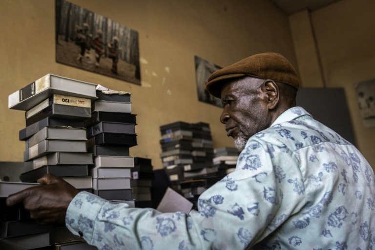 Aaron Loufimpou, conservateur d'archives audiovisuelles, empile des bandes de Télé-Congo dans la salle d'archives de l'ancien siège de la télévision à Brazzaville, le 3 mars 2026 au Congo