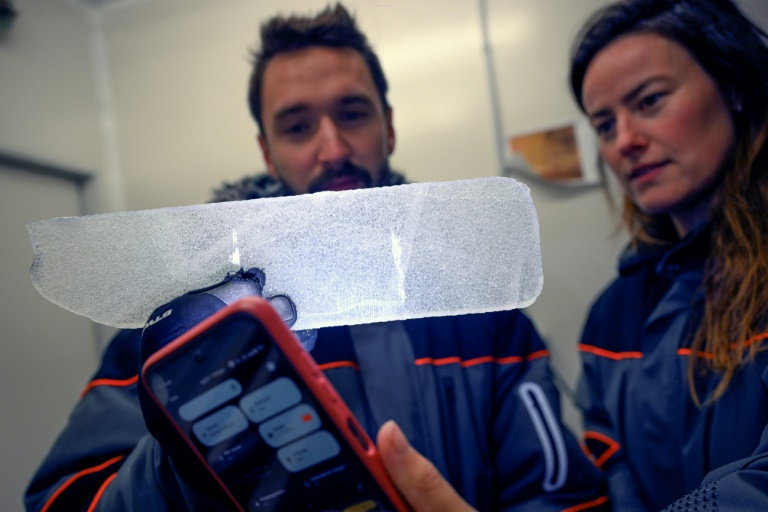 Des scientifiques examinent une carotte glaciaire antarctique dans un laboratoire à Bruxelles, le 15 juillet 2025 en Belgique