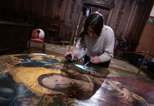 Une experte travaille à la restauration de "La Vierge au buisson de roses" peinte en 1473 par Martin Schongauer, le 5 mars 2026 dans l'église des Dominicains à Colmar, dans le Haut-Rhin