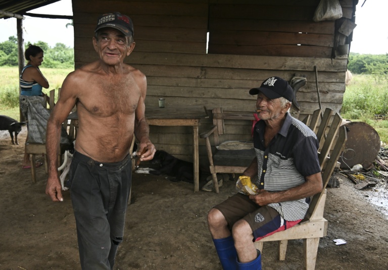 Fidel Maqueira (à gauche) se tient aux côtés de Victorino Maqueira devant leur maison à Consolacion del Sur, à Cuba, le 26 juillet 2026