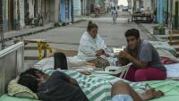 Plusieurs familles passent la nuit sur des lits installés dans la rue, dans un quartier central de La Havane, le 30 juillet 2026, après l'effondrement partiel de leur immeuble