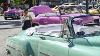 Une touriste prend en photo une voiture américaine dans une rue de La Havane, le 11 février 2026 à Cuba