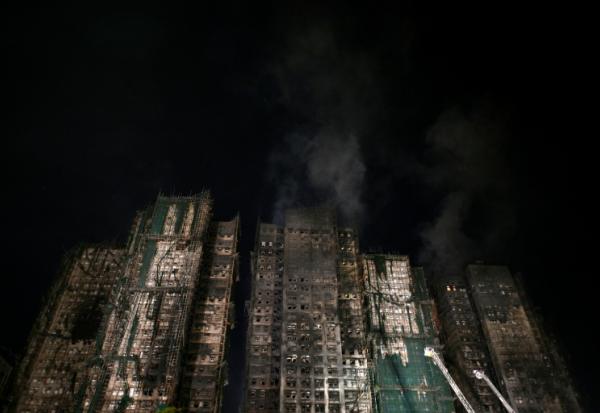 Les tours fumantes du complexe résidentiel Wang Fuk Court où un incendie s'est déclaré la veille, le 27 novembre 2025 à Hong Kong