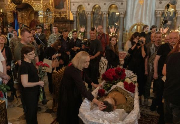 Des proches et des amis pleurent près du cercueil d’Oleksiï Ioukov, chef de l'unité de recherche ukrainienne Platsdarm, lors de ses funérailles à Kiev, le 8 août 2026