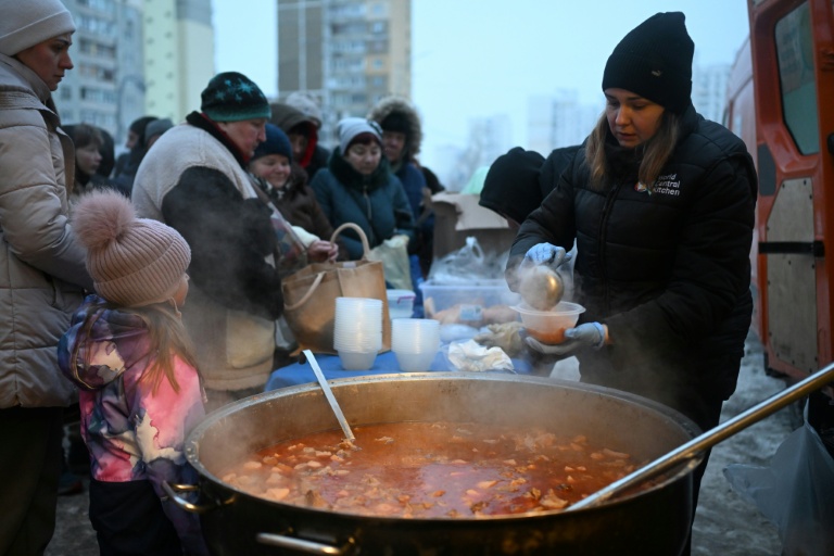 Des bénévoles de l'organisation caritative américaine World Central Kitchen distribuent un repas chaud aux habitants d'un quartier de Kiev, privé d'électricité et d'eau en raison de frappes russes, le 22 janvier 2026, en Ukraine