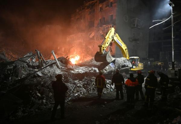 Des pompiers s'affairent dans les ruines d'un immeuble détruit par un raid aérien russe à Kharkiv, en Ukraine, le 2 janvier 2026 
