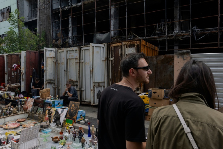 Des vendeurs du marché aux puces de Potchaïna endommagé par une frappe russe, à Kiev, le 9 août 2026 en Ukraine