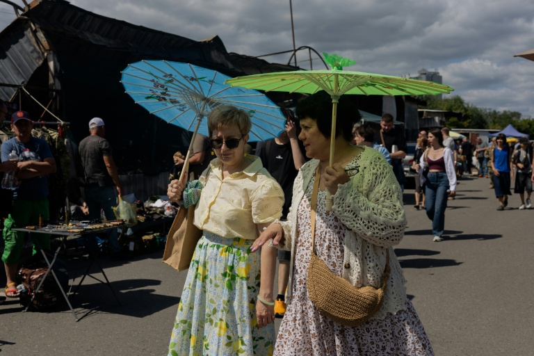 Des visiteuses au marché aux puces de Potchaïna endommagé par une frappe russe, le 9 août 2026 à Kiev, en Ukraine