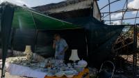 Vadym vend des objets sur son étal du marché aux puces de Potchaïna endommagé par une frappe russe, le 9 août 2026 à Kiev, en Ukraine