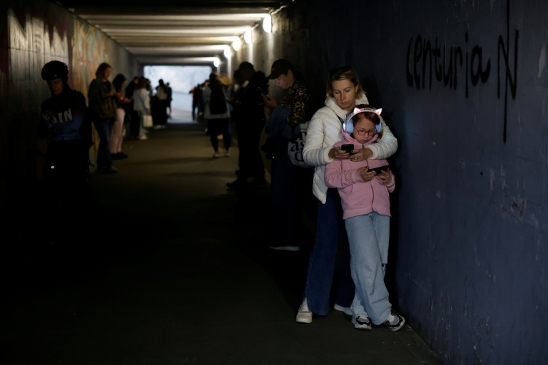 A Kiev, des passants s'abritent dans un passage souterrain pendant une alerte avertissant du danger de frappes russes, le 4 octobre 2026