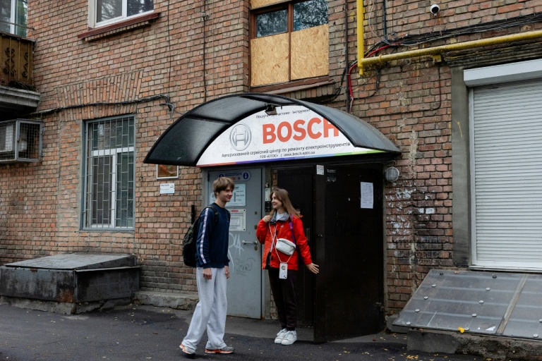 Anastassiia Jmoutskaet son fils Oreste se rendent à l'école après une alerte aérienne, à Kiev, le 13 octobre 2026 en Ukraine