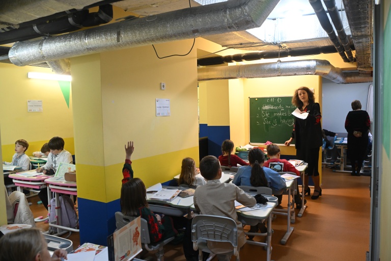 Des écoliers ont classe dans un abri installé au sous-sol de leur école primaire pendant une alerte aérienne en banlieue de Kiev, le 20 octobre 2026