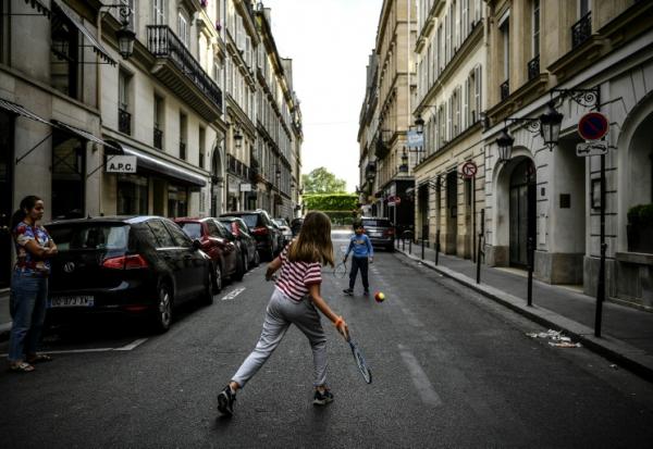 Des enfants jouent au tennis dans une rue de Paris le 21 avril 2020, en plein confinement lié au Covid-19 