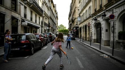 Des enfants jouent au tennis dans une rue de Paris le 21 avril 2020, en plein confinement lié au Covid-19 