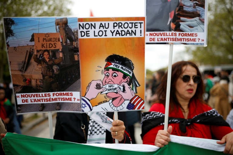 (ARCHIVES) Une personne brandit une pancarte sur laquelle on peut lire « Non au projet de loi Yadan » alors que des manifestants participent à un rassemblement contre ce projet de loi, qui vise à lutter contre les nouvelles formes d'antisémitisme, à Paris, le 12 avril 2026.