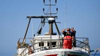 Un pêcheur sur le pont de son bateau alors qu'il arrive pour décharger sa pêche au port de Lampedusa après une journée en mer, le 8 juillet 2026 en Italie