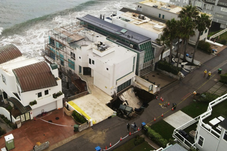 Vue aérienne montrant un gouffre apparu dans la rue et l'allée d'une maison en bord de mer, endommagée par les fortes houles provoquées par l'ouragan Marie à Malibu, en Californie, le 8 septembre 2026