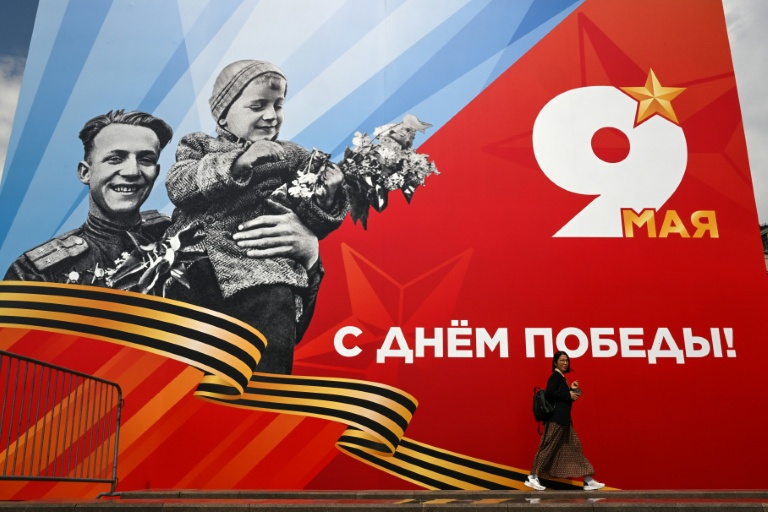 Une femme passe devant une affiche célébrant le 