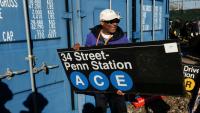 Le réalisateur Spike Lee tient une panneau d'une station de métro qu'il vient d'acheter lors de la vente annuelle organisée par la régie des transports de New York (MTA), le 9 octobre 2026
