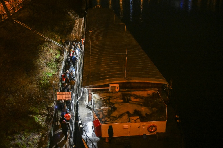 Des personnes font la queue pour passer la nuit sur l'Hermes, une péniche amarrée près de l'un des nombreux ponts qui enjambent la rivière Vltava à Prague, où le nombre de sans-abri connaît une augmentation inquiétante, le 26 janvier 2026