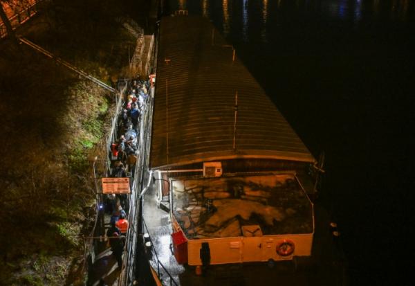 Des personnes font la queue pour passer la nuit sur l'Hermes, une péniche amarrée près de l'un des nombreux ponts qui enjambent la rivière Vltava à Prague, où le nombre de sans-abri connaît une augmentation inquiétante, le 26 janvier 2026