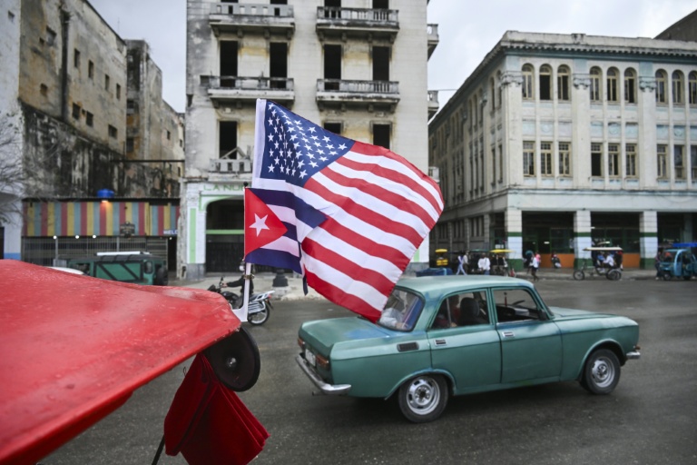 Un drapeau cubain et un drapeau américain flottent sur le toit d'un tricycle à La Havanne, le 30 janvier 2026 
