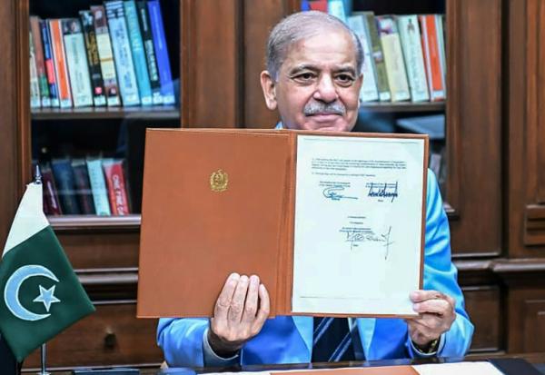 Le Premier ministre pakistanais Shehbaz Sharif montre le protocole d'accord signé par les présidents américain et iranien, après l'avoir lui-même signé en tant que médiateur, le 18 juin 2026 à Islamabad