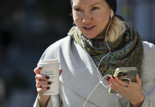 Une femme se déplace dans la rue avec son gobelet de café à New York, le 16 octobre 2025.