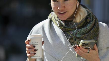 Une femme se déplace dans la rue avec son gobelet de café à New York, le 16 octobre 2025.
