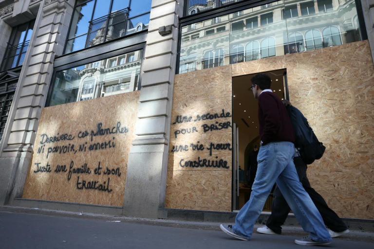 Une boutique protégée par des plaques de bois à Paris en prévision des manifestations, le 30 octobre 2026