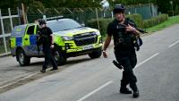 Des policiers armés devant la base de la RAF à Fairford, le 28 septembre 2026, dans le sud-ouest de l'Angleterre, au lendemain de l'intervention de la police antiterroriste britannique