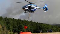 Des hélicoptères de la police chargent de l'eau pour lutter contre un incendie de forêt à Hurtgenwald, dans l'ouest de l'Allemagne, le 14 août 2026