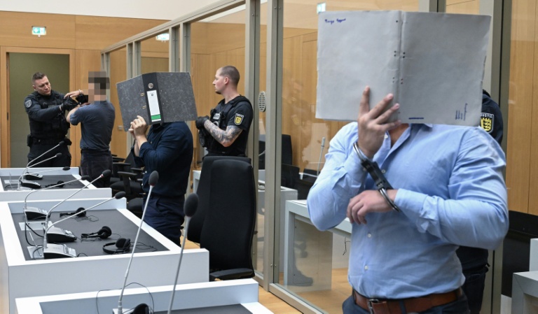 (g-d) Trois ressortissants Ukrainiens, Daniil B., Vladyslav T. et Yevhen B., poursuivis pour avoir aidé les services secrets russes à des fins de sabotages à l'explosif, attendent leur verdict au tribunal régional de Stuttgart-Stammheim, dans le sud de l'Allemagne, le 18 août 2026