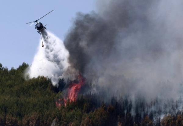 Un hélicoptère Airbus H125 largue de l'eau sur un incendie de forêt à Taradeau, le 20 juillet 2026 dans le Var