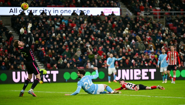 Le gardien de Sunderland Robin Roefs (à gauche) dégage une frappe de la tête de Josko Gvardiol (au centre) lors du match de Premier League contre Manchester City le 1er janvier 2026 à Sunderland
