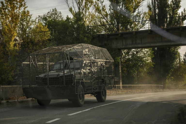 Un véhicule blindé transportant une cage de protection contre les attaques de drones circule sur une route près de Droujkivka, dans l'est de l'Ukraine, le 3 octobre 2025