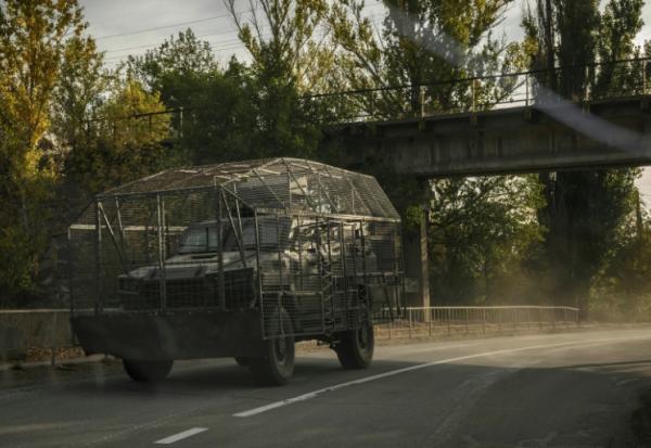 Un véhicule blindé transportant une cage de protection contre les attaques de drones circule sur une route près de Droujkivka, dans l'est de l'Ukraine, le 3 octobre 2025