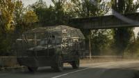 Un véhicule blindé transportant une cage de protection contre les attaques de drones circule sur une route près de Droujkivka, dans l'est de l'Ukraine, le 3 octobre 2025