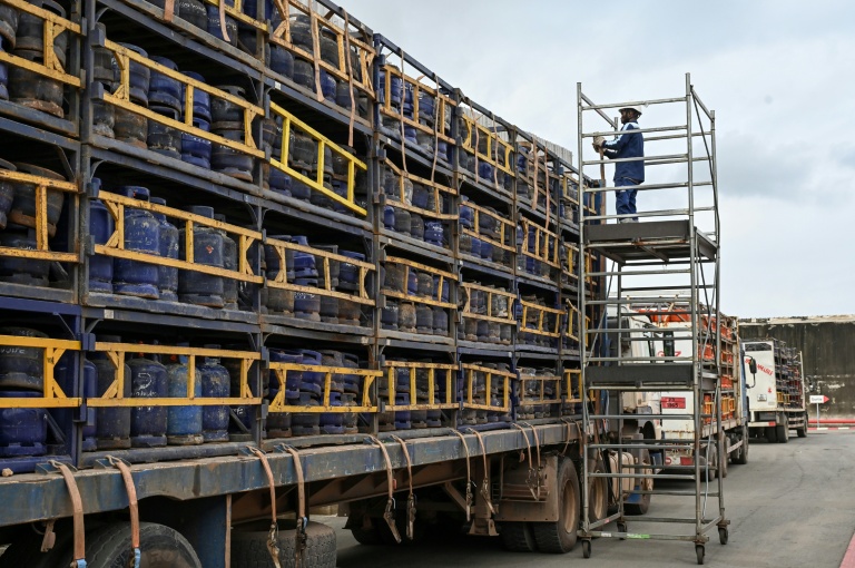 Des employés chargent des bouteilles de gaz sur des camions avant leur expédition depuis le site de l'entreprise Petro Ivoire, dans la zone industrielle de Vridi, à Abidjan, le 7 juillet 2026 en Côte d'Ivoire