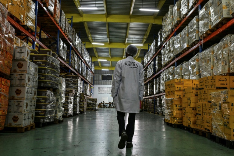 Un employé dans un entrepôt où des palettes de produits cosmétiques  attendent d'être expédiées, à l'usine de fabrication de cosmétiques Kaera dans la zone industrielle de Yopougon, en périphérie d'Abidjan, le 7 juillet 2026 en Côte d'Ivoire