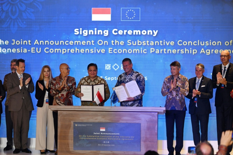 Le ministre indonésien de l'Economie, Airlangga Hartarto (au centre à g.), et le commissaire européen au commerce, Maros Sefcovic (au centre à d.), posent sur scène après avoir paraphé l'accord de libre-échange entre l'Indonésie et l'UE sur l'île indonésienne de Bali, le 23 septembre 2025