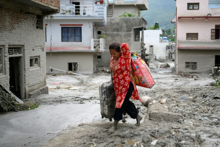 Une femme transporte ses affaires à Devighat, dans le district de Nuwakot au Népal, le 28 août 2026