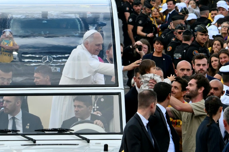 Le pape Leon XIV bénit un enfant lors de sa descente des Champs-Elysées en papamobile, avant de célébrer une messe géante place de la Concorde à Paris, le 26 septembre 2026