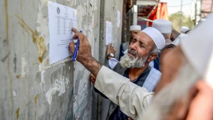 Un retraité vérifie une liste devant un bâtiment gouvernemental à Kabou, le 25 août 2025 en Afghanistan