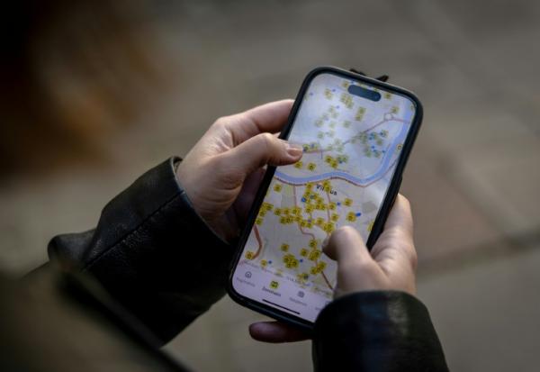 Ruta Gaskauskaite présente sur son téléphone une application qui permet aux utilisateurs de trouver les abris les plus proches, à Vilnius, le 28 mai 2026, en Lituanie