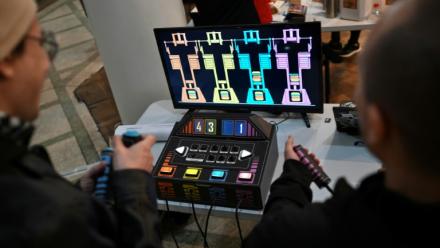 Des personnes jouent à un jeu vidéo fabriqué à partir de composants électroniques recyclés lors de la 3e Rencontre fédérale Cyberciruja à Buenos Aires, le 16 août 2025 en Argentine