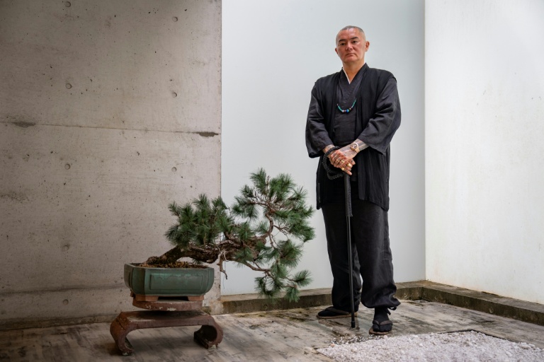 Remy, tatoueur professionnel, pose dans son studio à Ginowan, dans la préfecture d'Okinawa au Japon, le 19 mai 2026 

